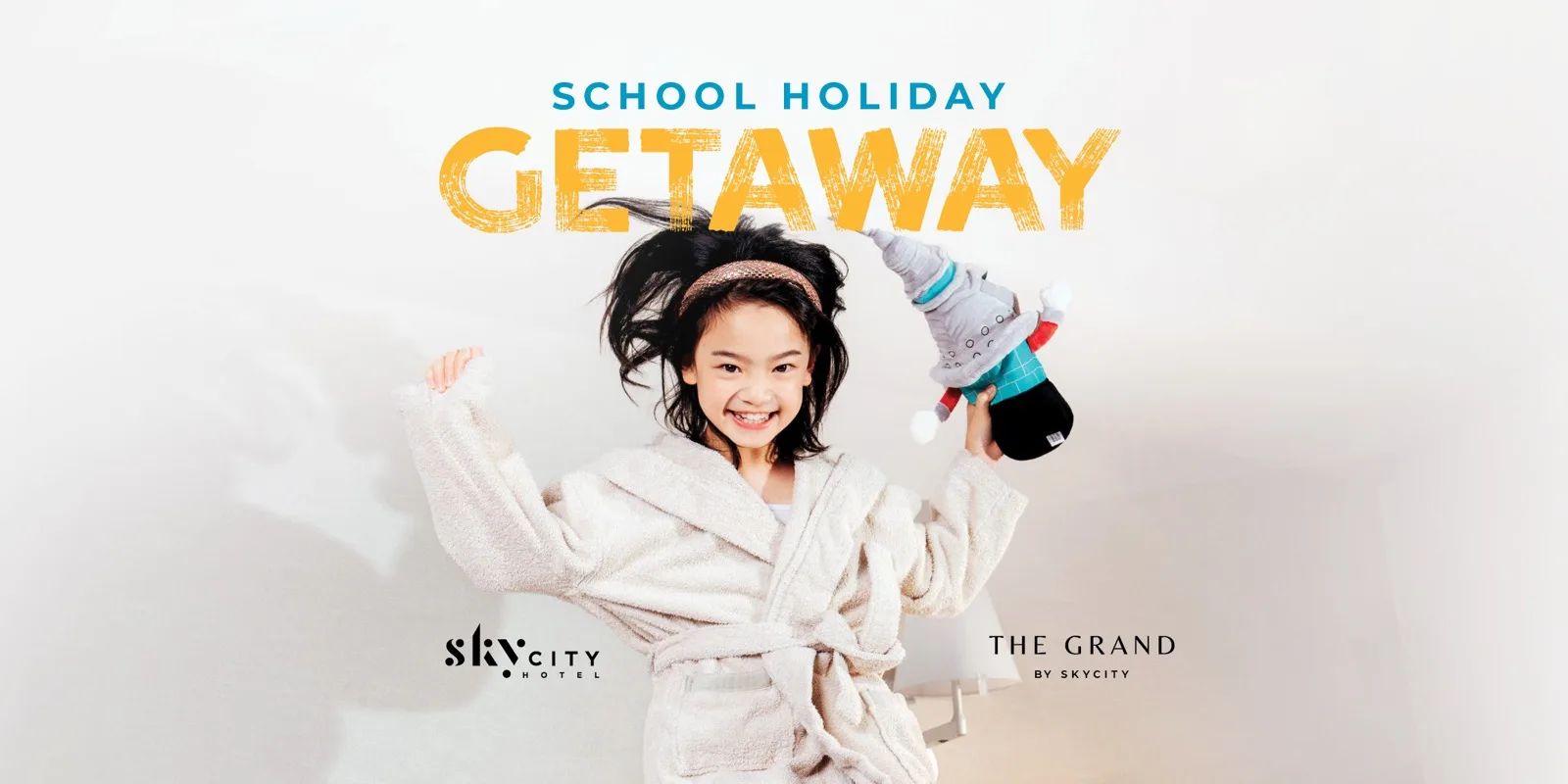 School Holidays hotel campaign artwork: a child in a robe holding a toy, under a blue and yellow brushed Getaway headline.